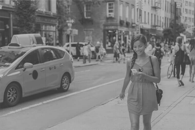 Young woman walking on busy city street